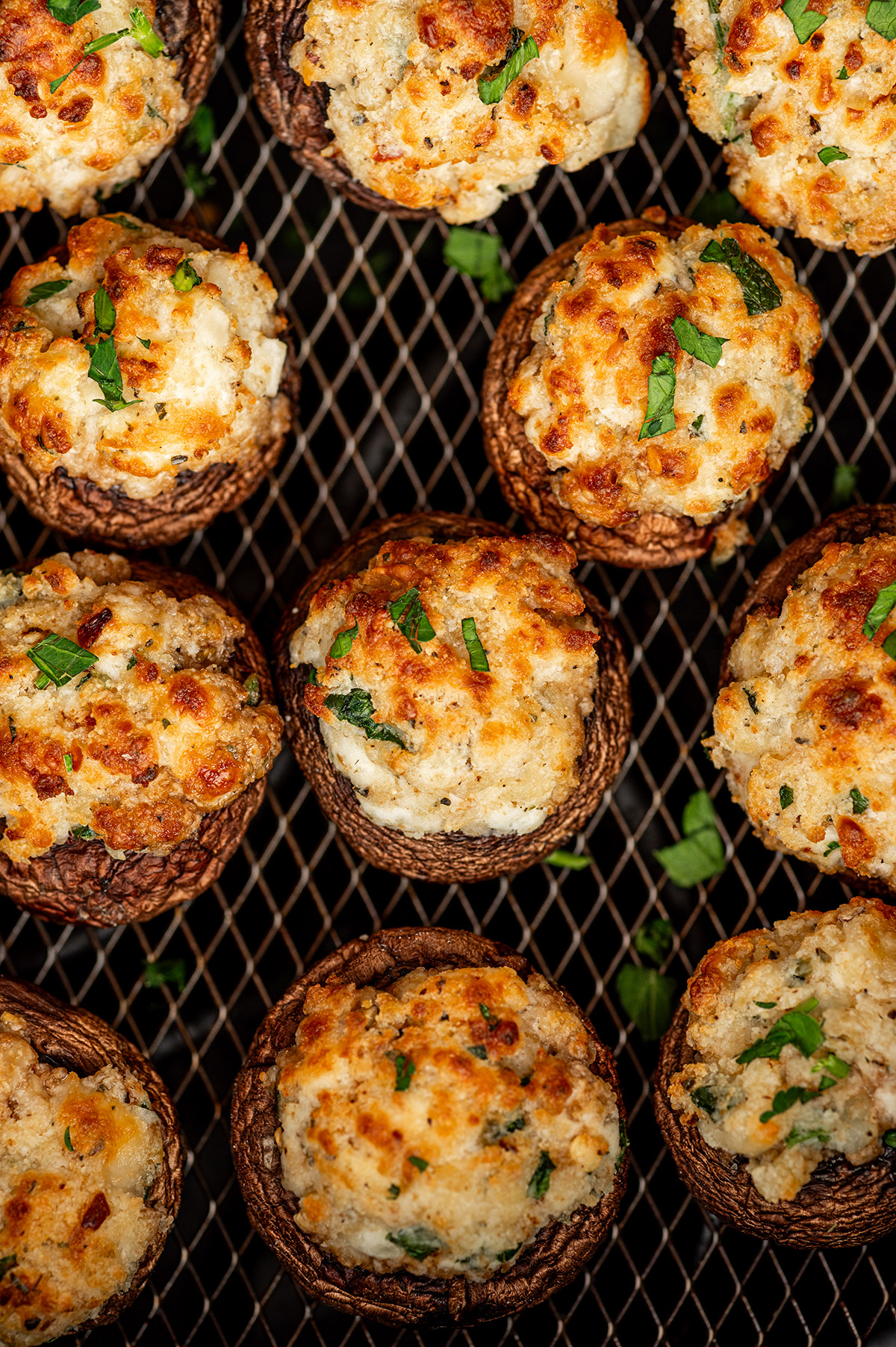 Crispy air fryer stuffed mushrooms in an air fryer basket.