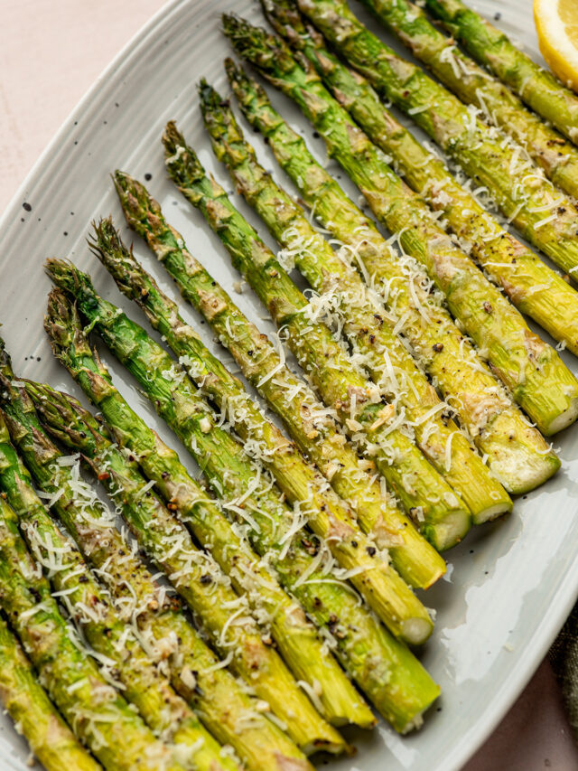 Oven roasted asparagus in a baking dish with parmesan and garlic.