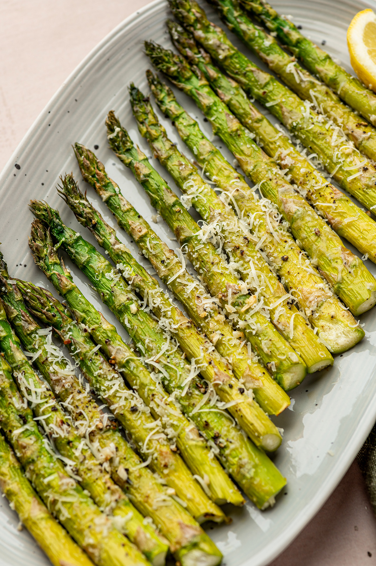 Oven roasted asparagus in a baking dish with parmesan and garlic.