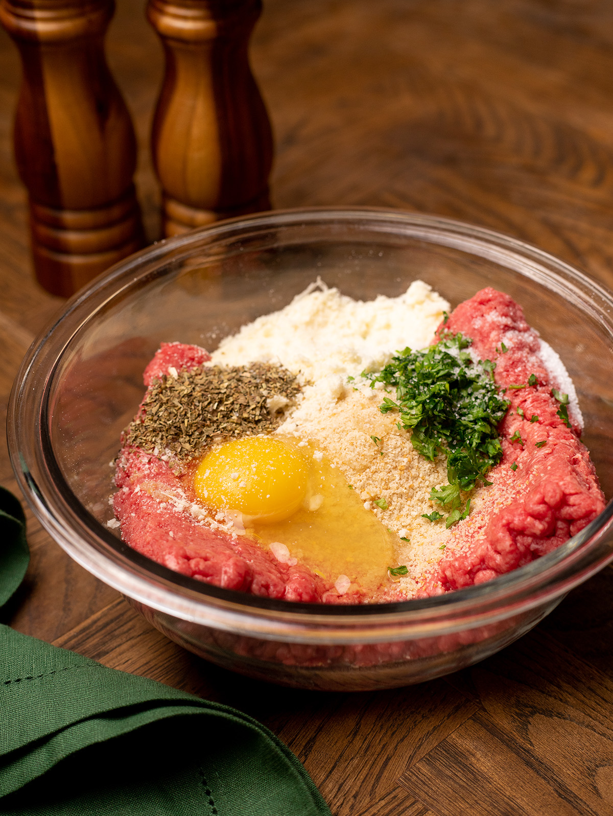 Ingredients for stuffed meatballs in a clear mixing bowl.