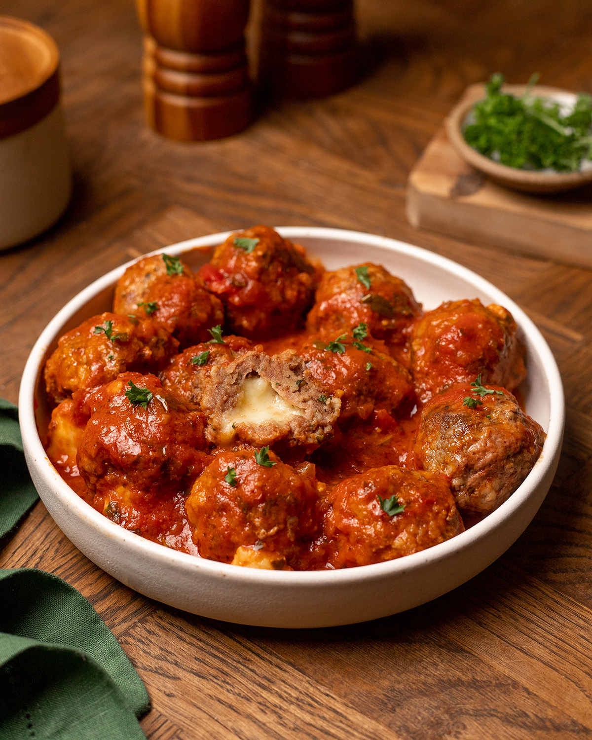 Stuffed meatballs in a white bowl covered in marinara sauce.