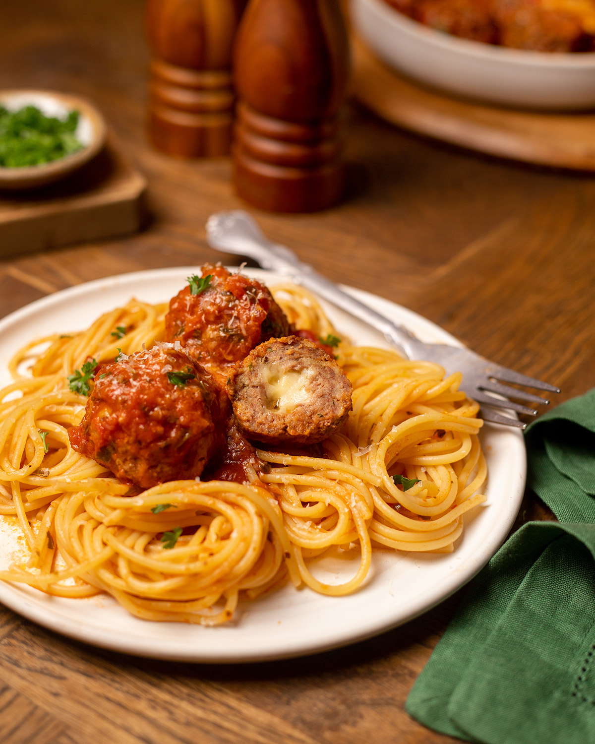 A serving of stuffed meatballs over a bed of spaghetti noodles.