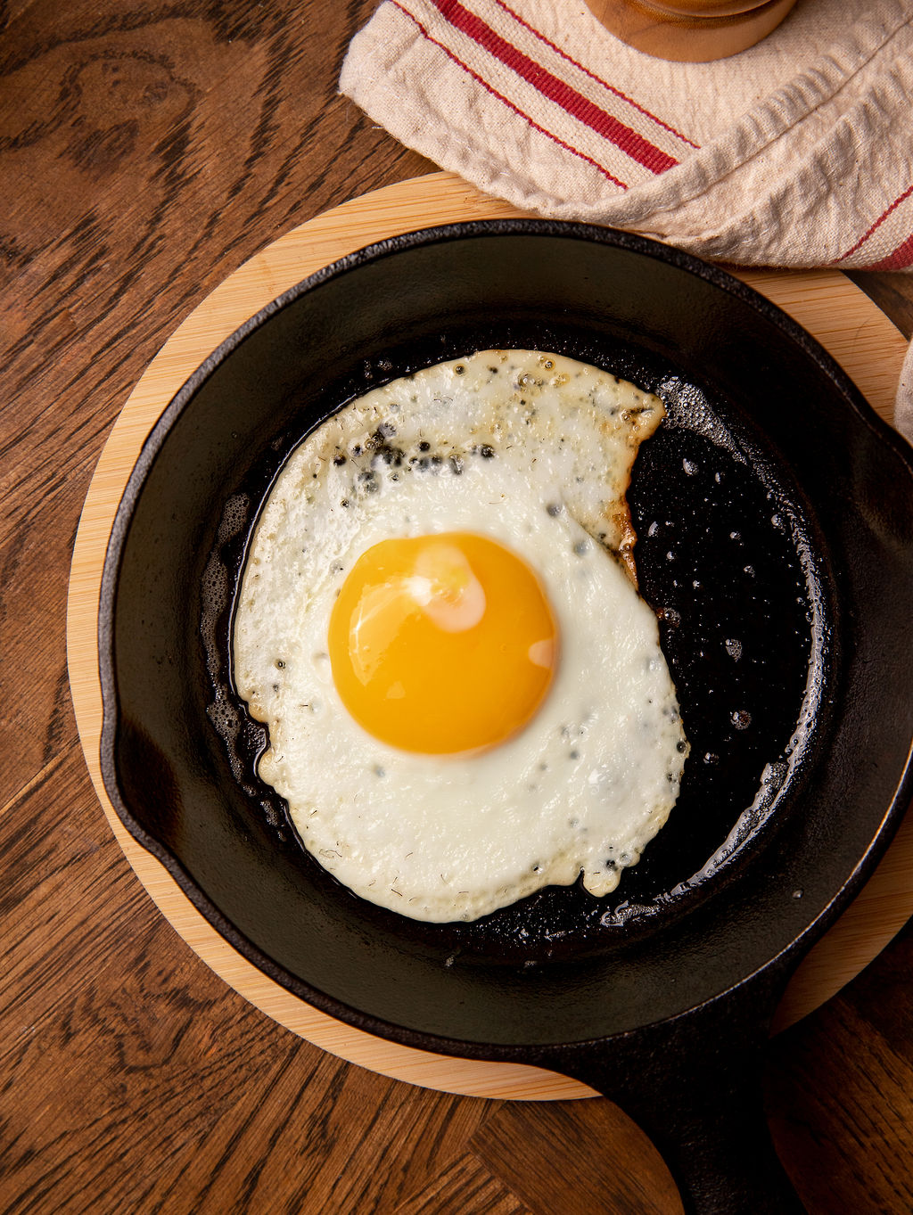 Cooking a sunny side up egg in a cast iron pan.