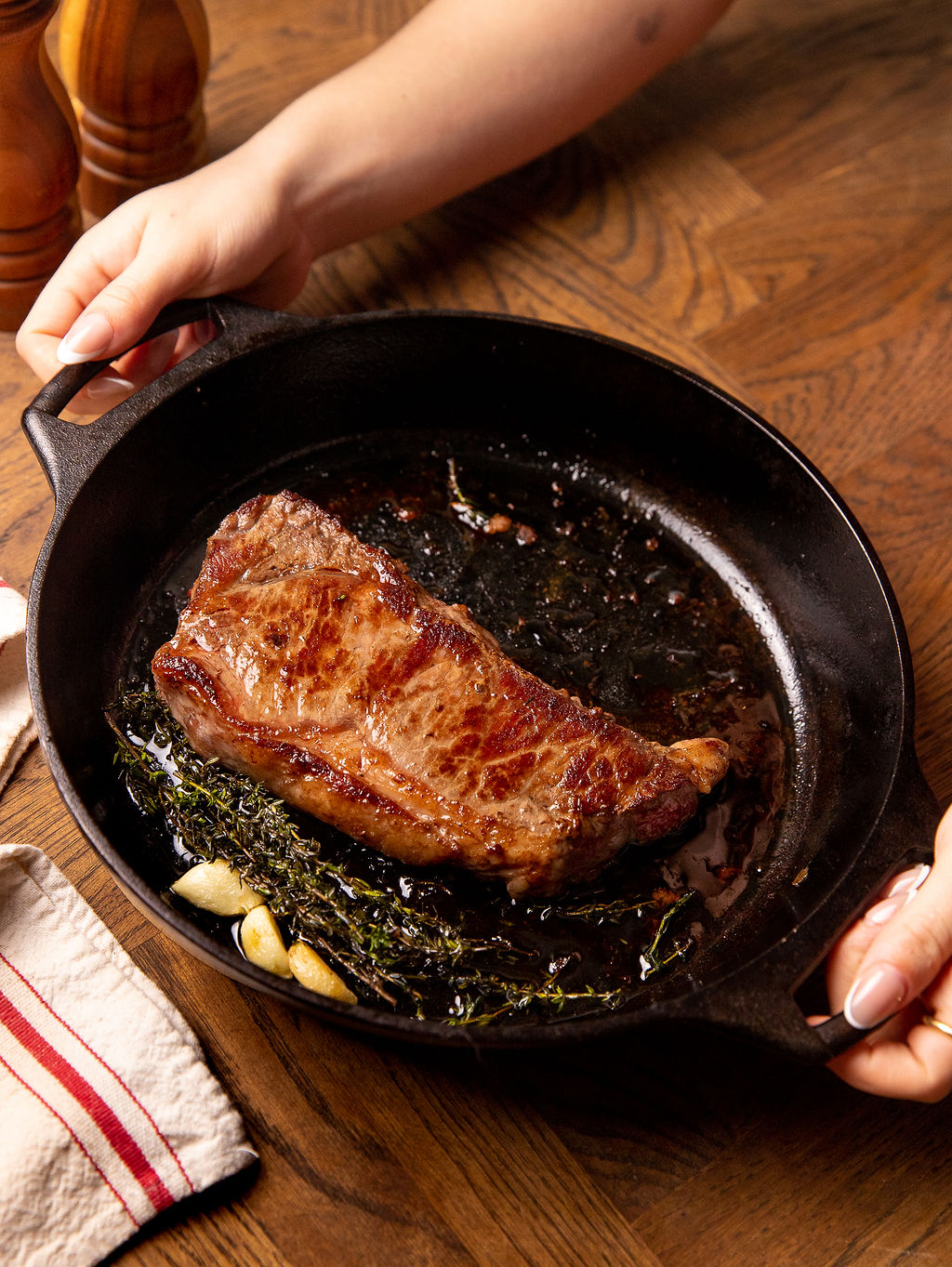 Cooking a steak in a cast iron skillet with butter and garlic.