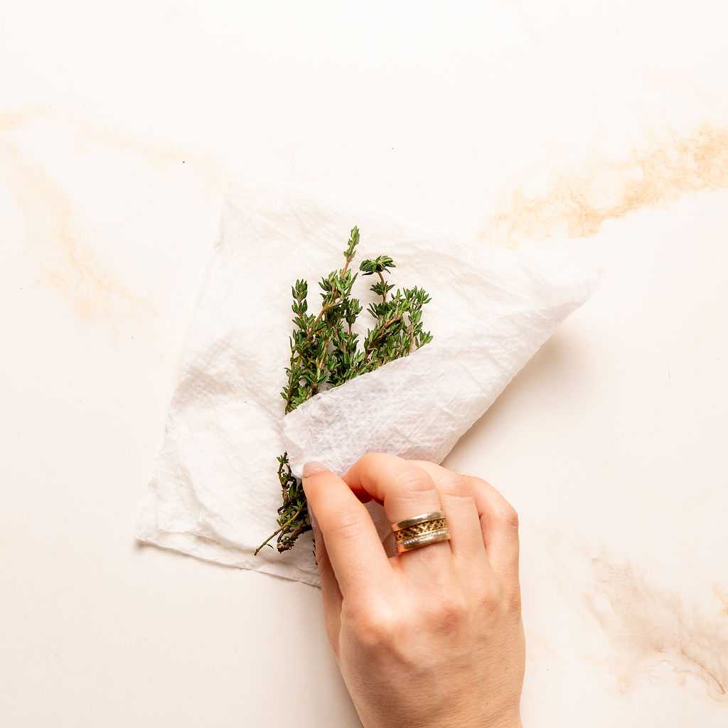 Wrapping up fresh thyme in a damp paper towel.