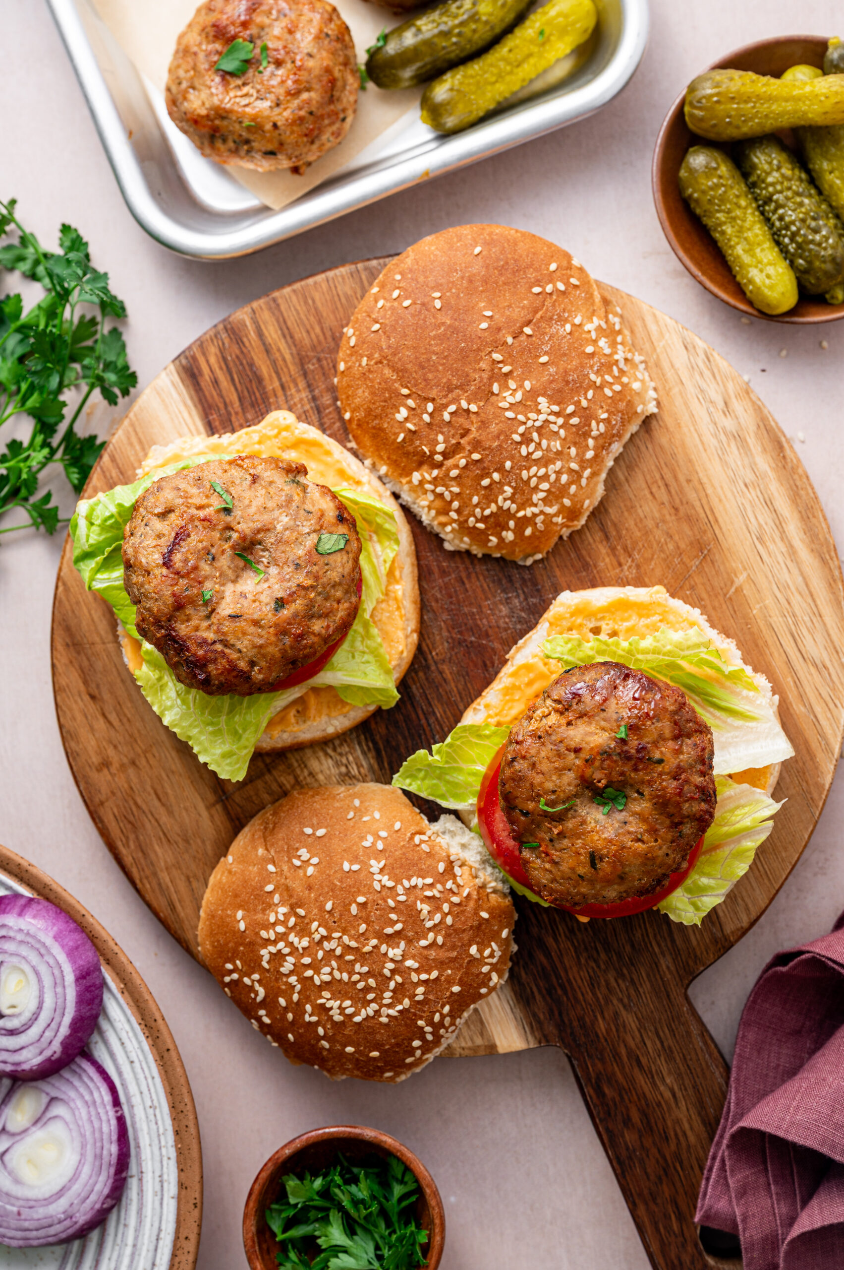 Hero shot of two open-faced air fryer turkey burgers on a wooden serving platter.
