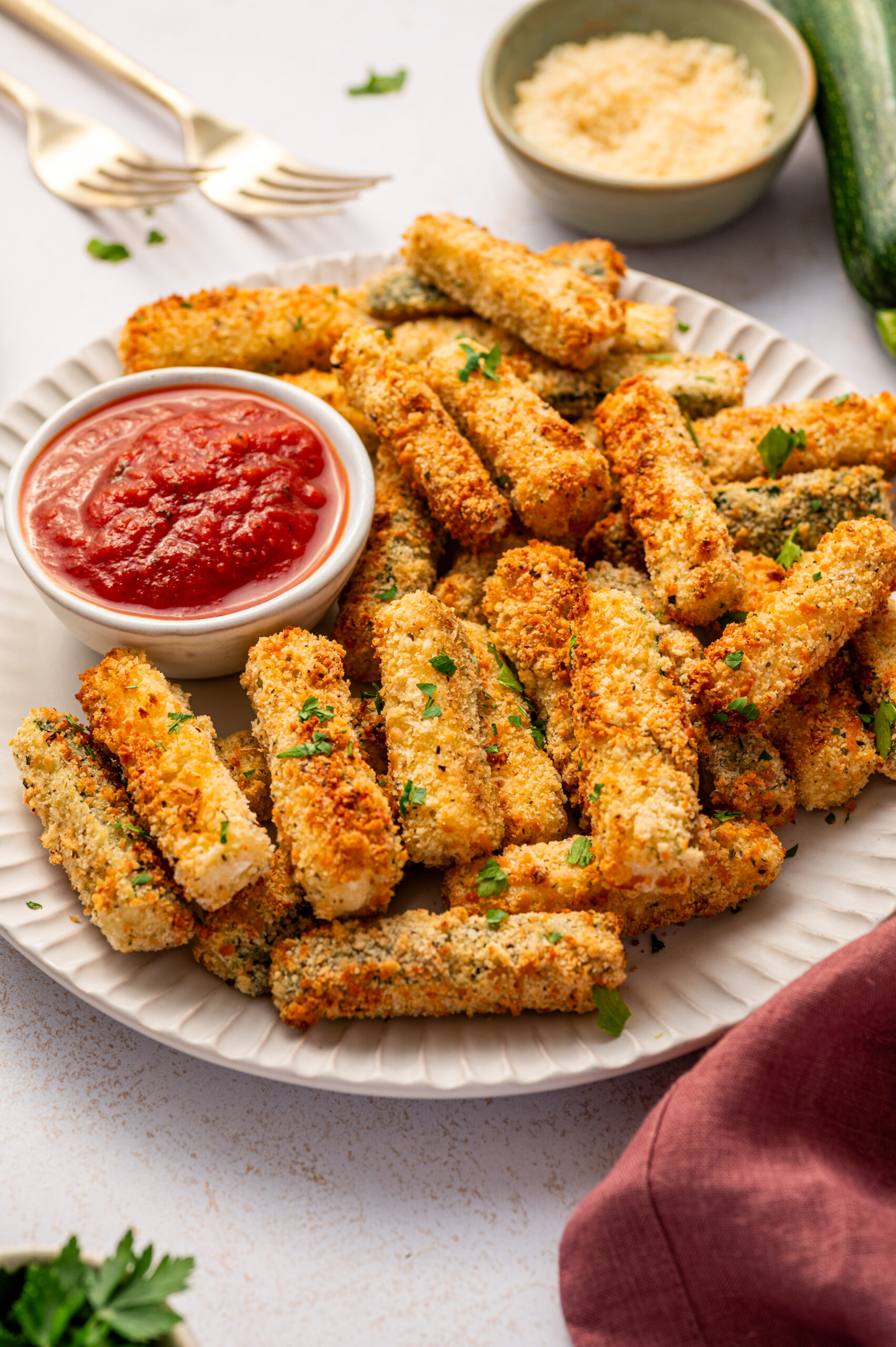 Air fryer zucchini fries on a white plate.