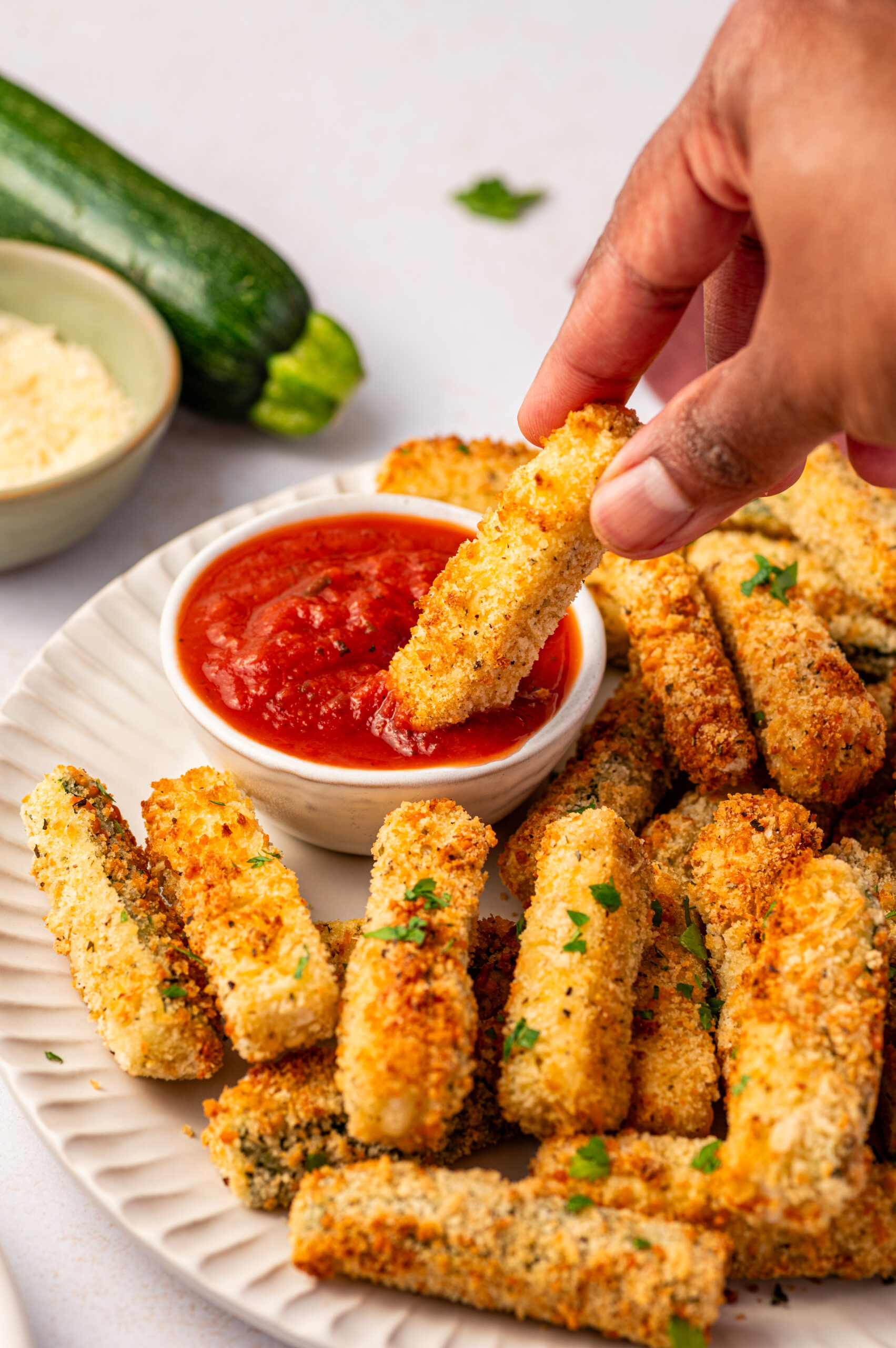 Dipping an zucchini fry in marinara sauce.