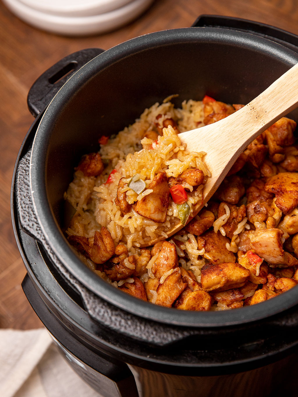 Cajun chicken and rice in an Instant Pot with a wooden spoon.