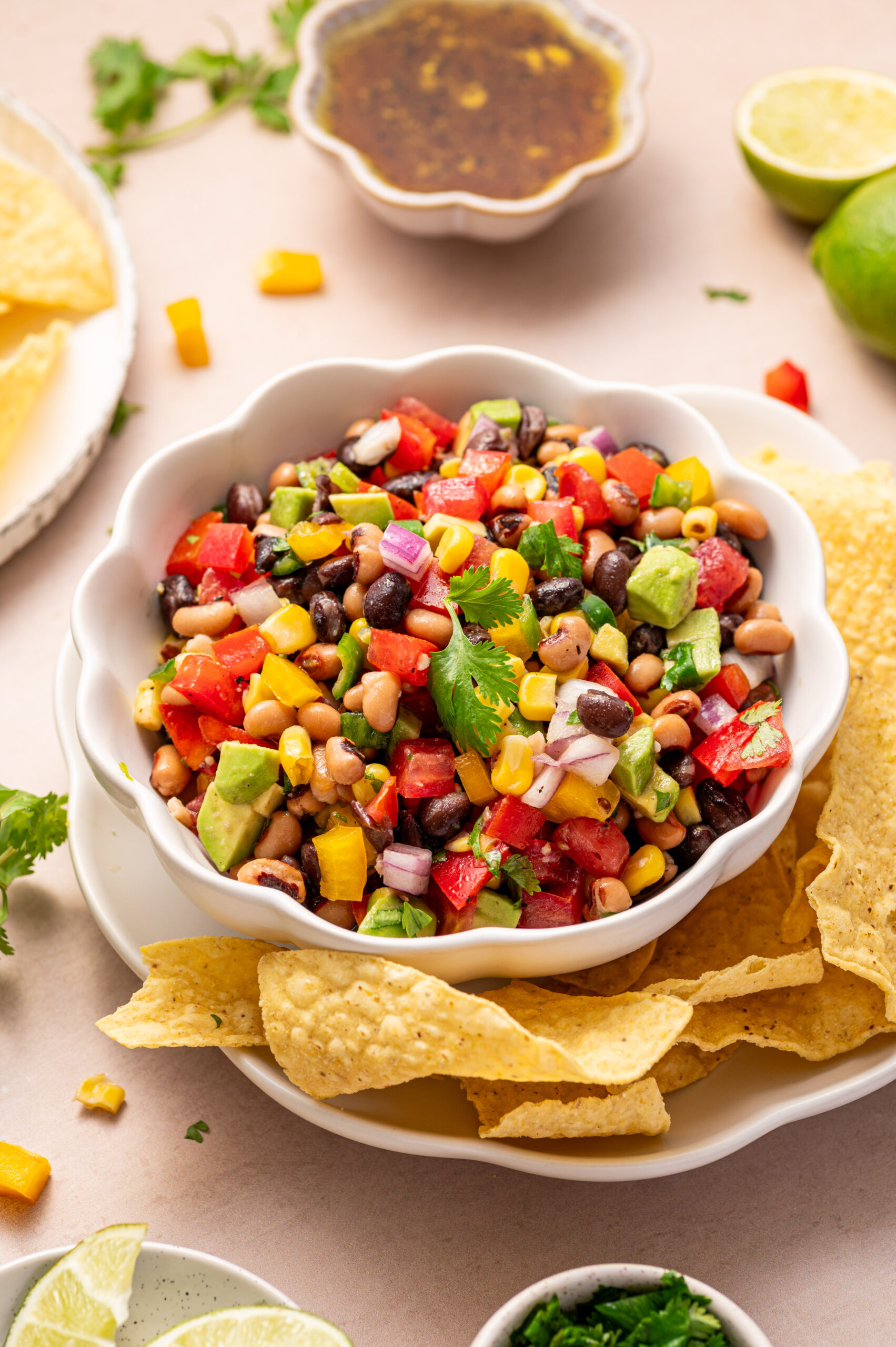 Cowboy caviar in a white serving bowl with tortillas chips on the side.