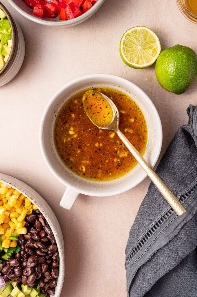 Cowboy caviar dressing in a white mug with silver spoon.