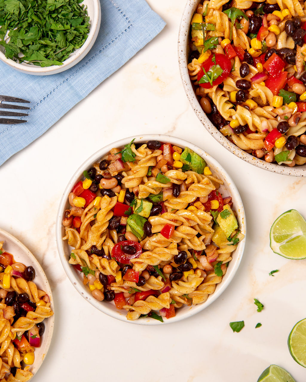 A hero shot of cowboy caviar pasta salad over a white surface.