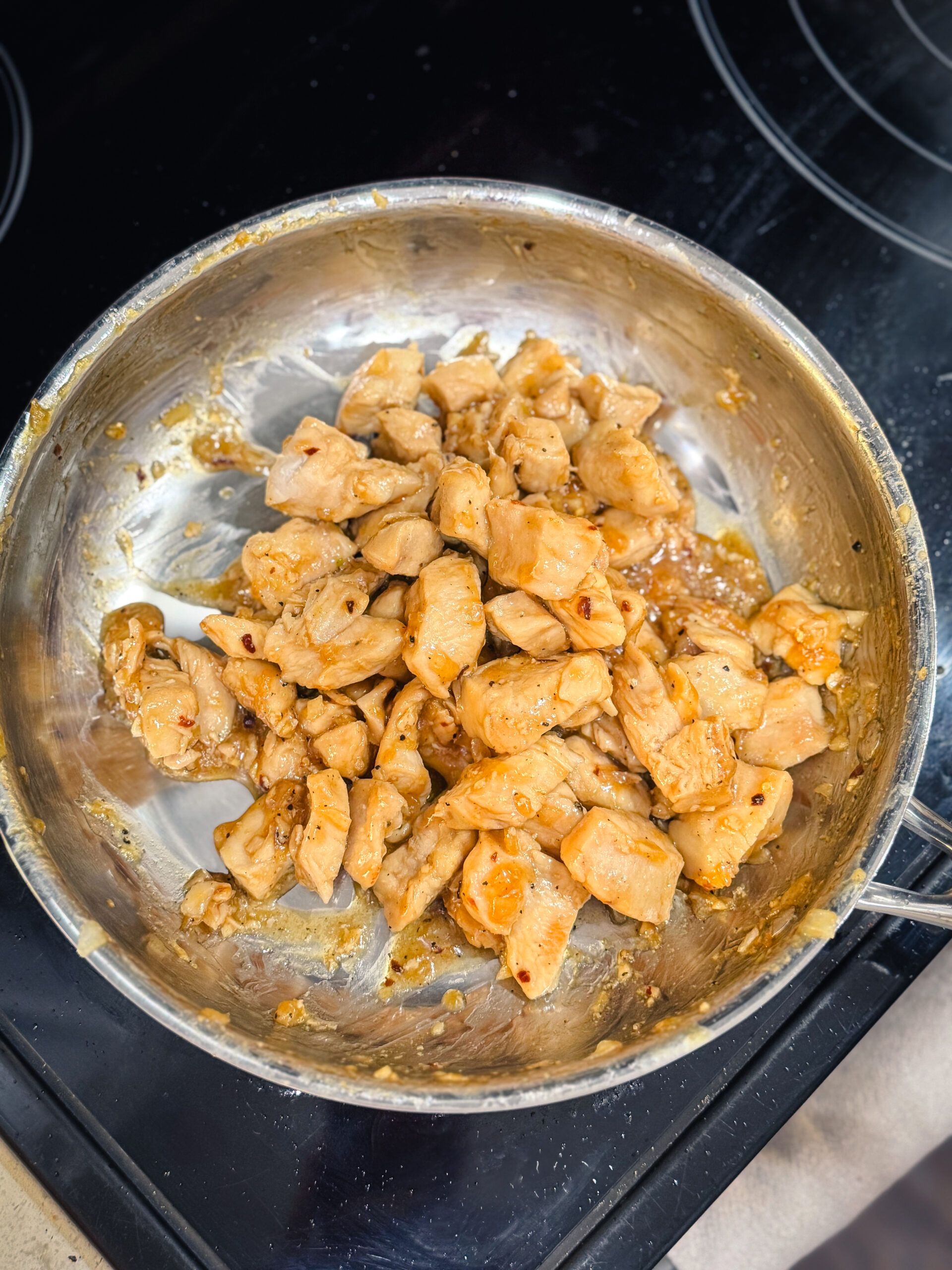 Ready-to-eat honey garlic chicken in a skillet over the stove.