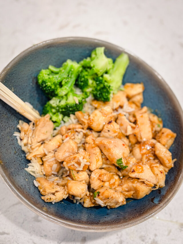 Honey garlic chicken on a blue plate with a side of broccoli.