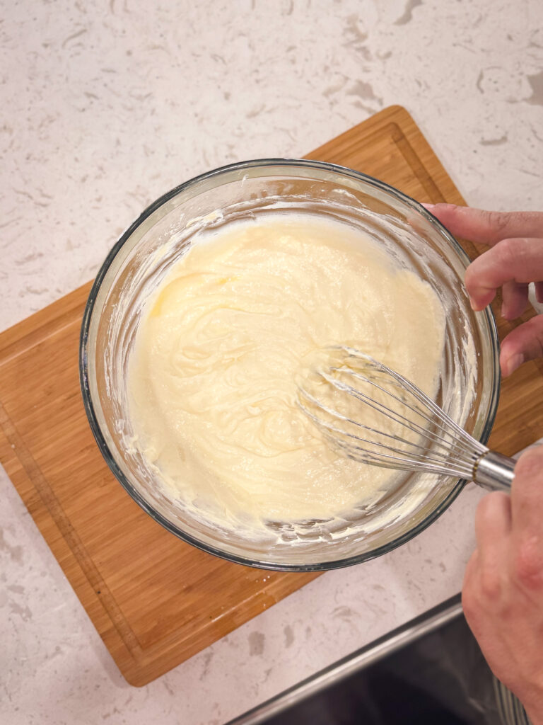 Whisking together the ricotta cheese and eggs.