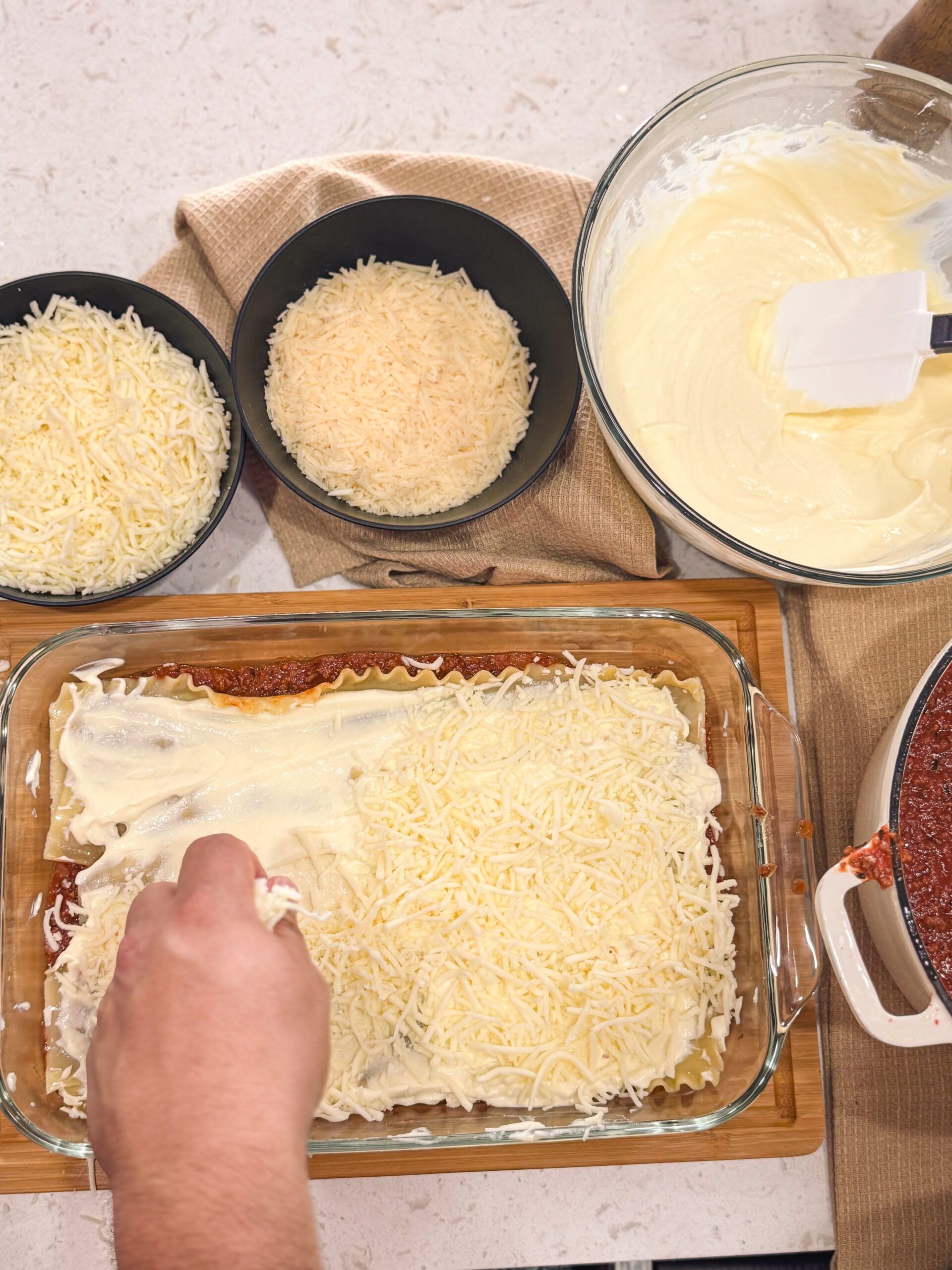 Layering on shredded cheese for oven baked lasagna.