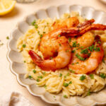 Close-up of roasted shrimp and orzo on a plate.