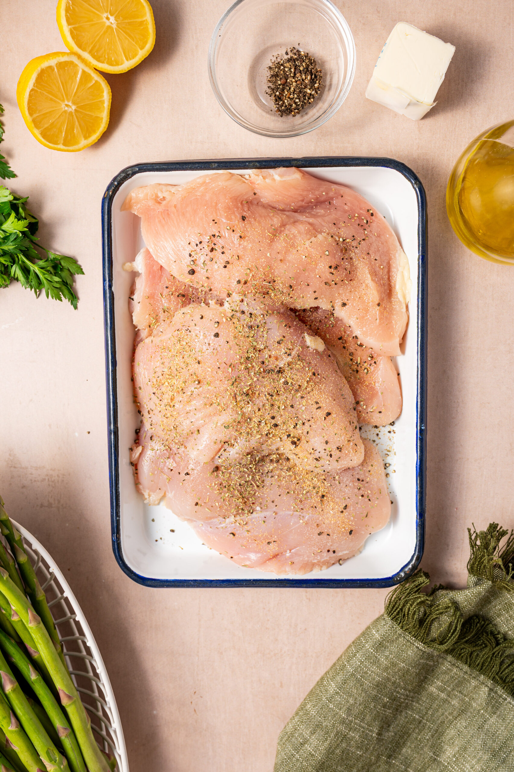 Raw chicken in a dish with seasoning.