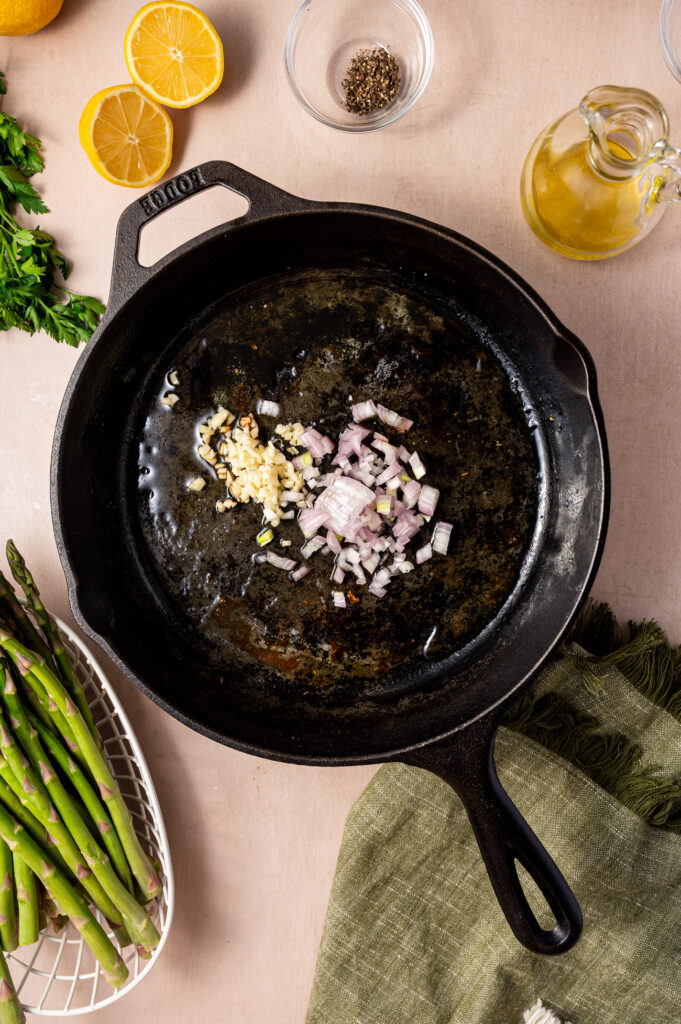 Shallots sauteing in a cast iron skillet.