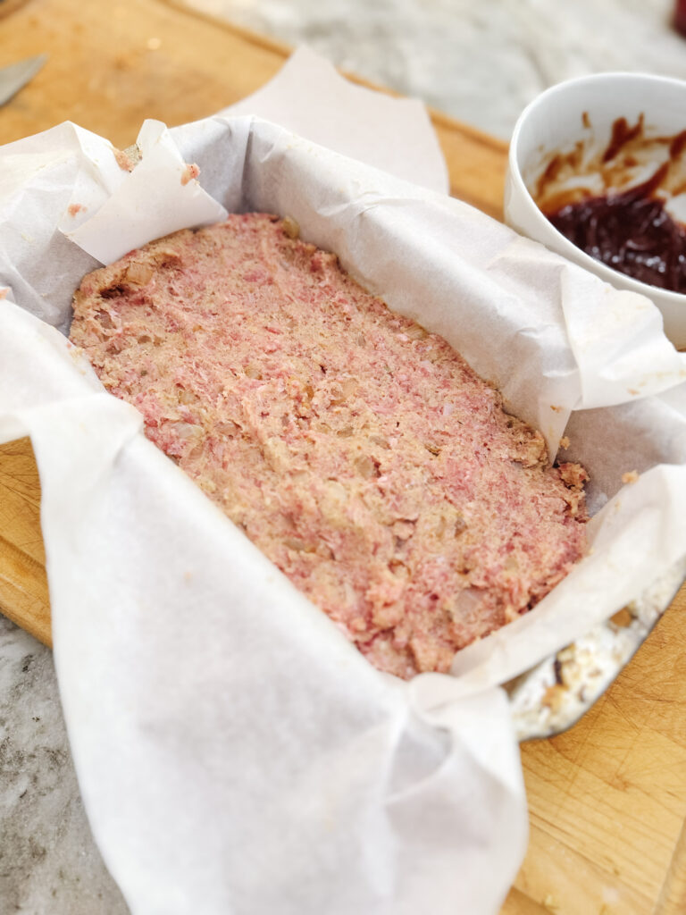 Classic meatloaf in a loaf pan ready to go in the oven!