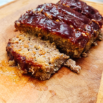 Classic meatloaf on a cutting board cut into slices.