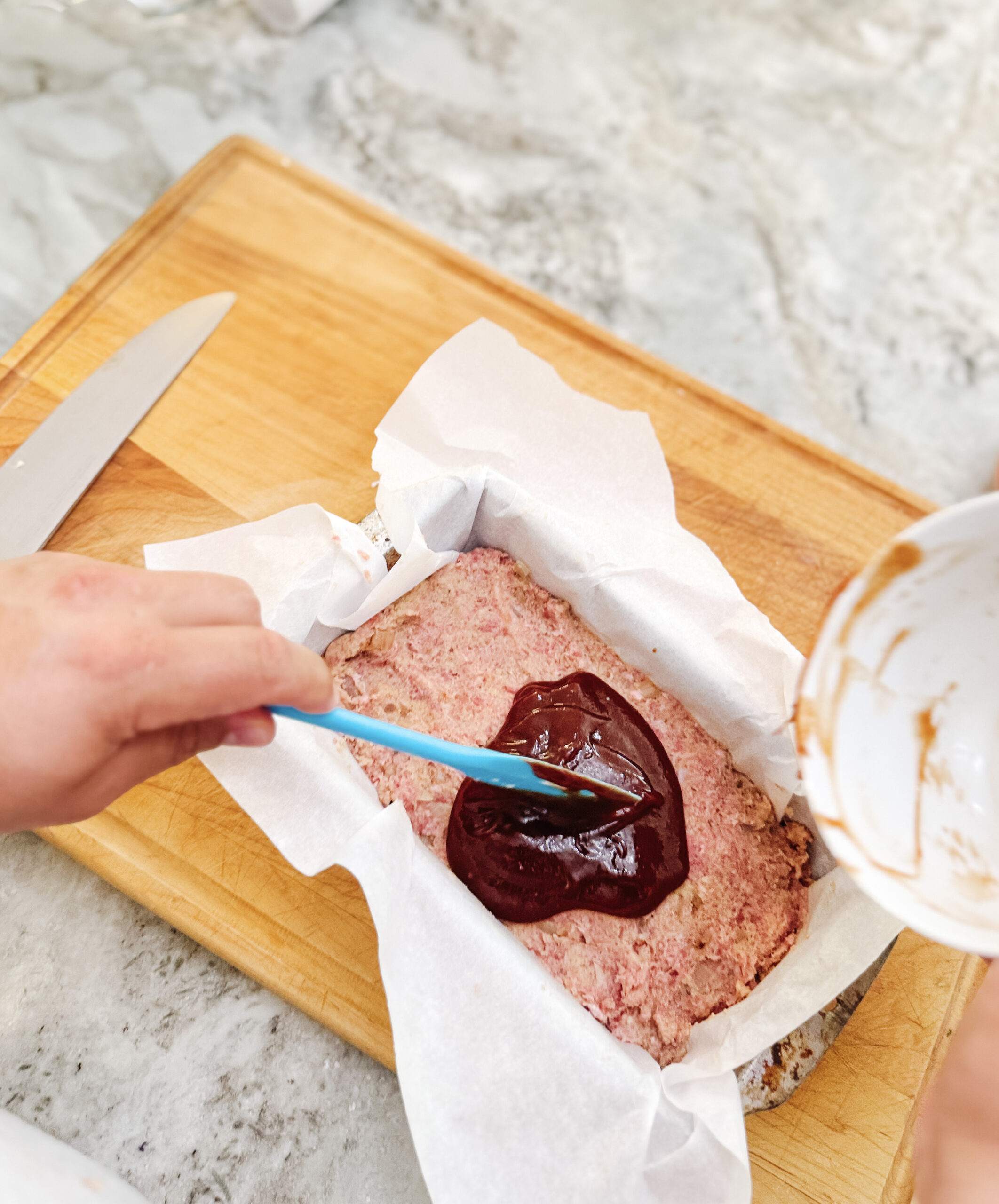 Adding the glaze to the top of the meatloaf