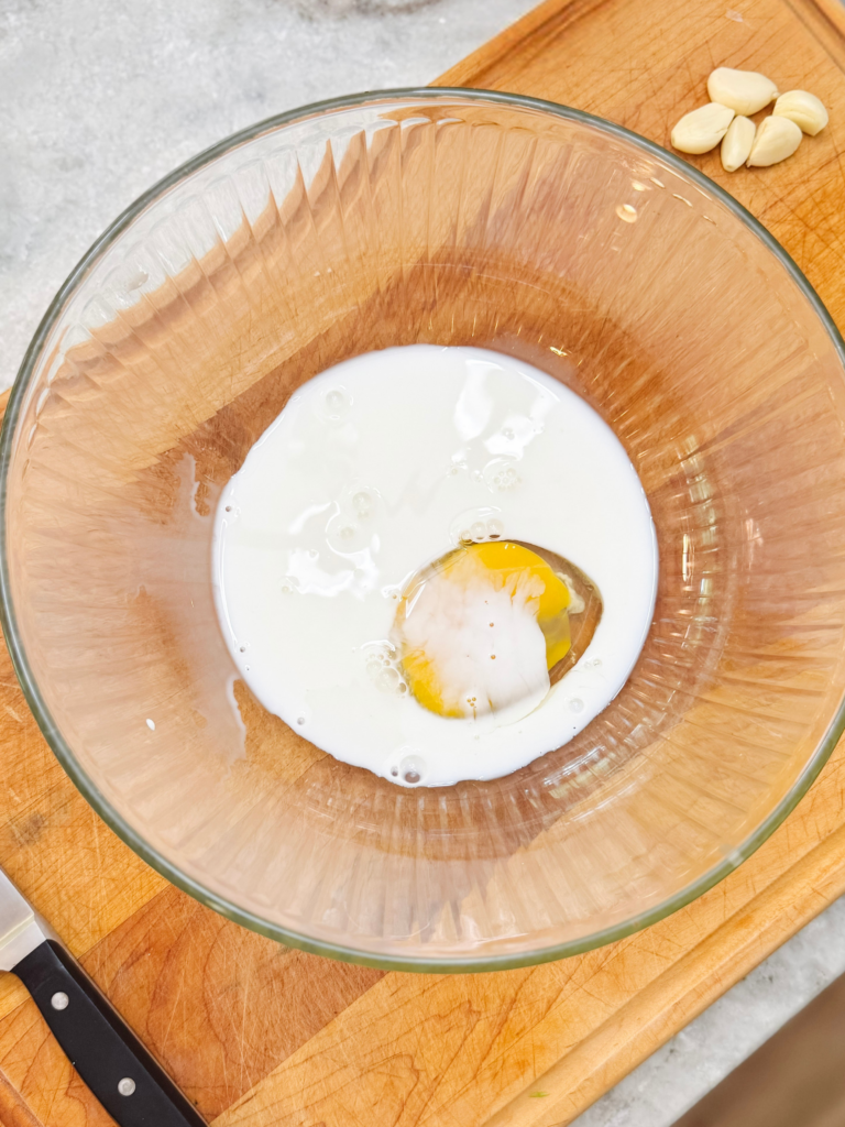 Marscarpone cheese and an egg in a glass bowl.