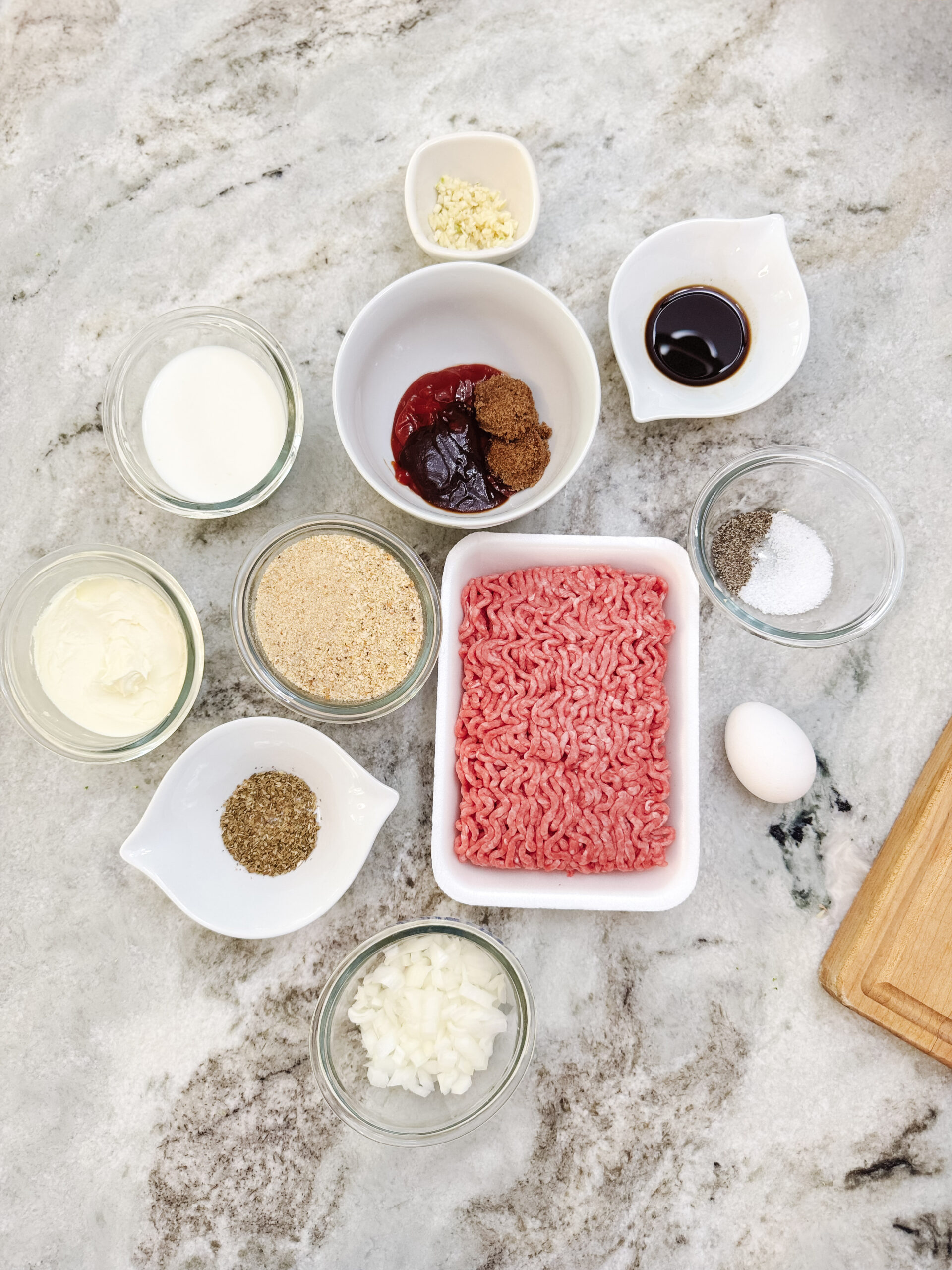 Ingredients for classic homestyle meatloaf on a gray marble surface.