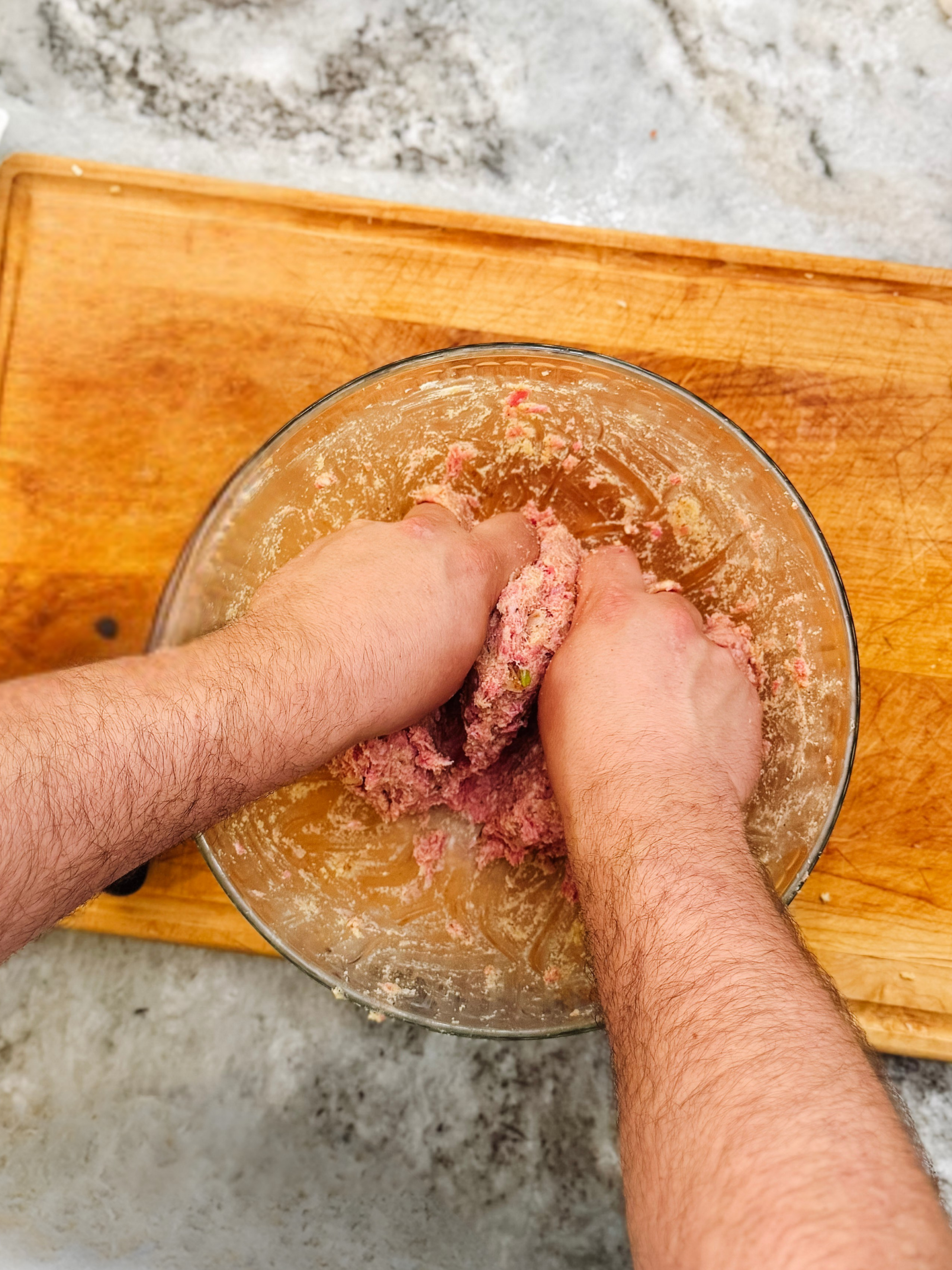 Mixing ground beef with egg and breadcrumbs in a bowl for classic meatloaf recipe.