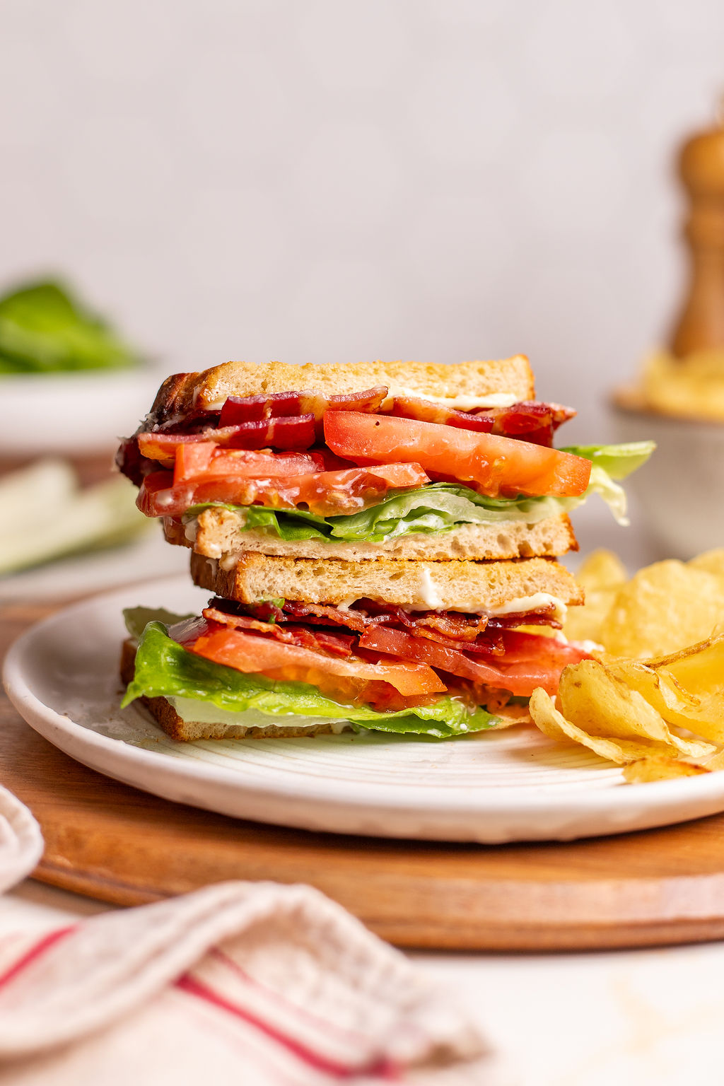 A tasty BLT sandwich on a plate with chips.