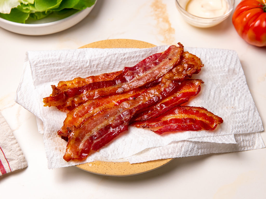 Crispy bacon on a plate with paper towel.