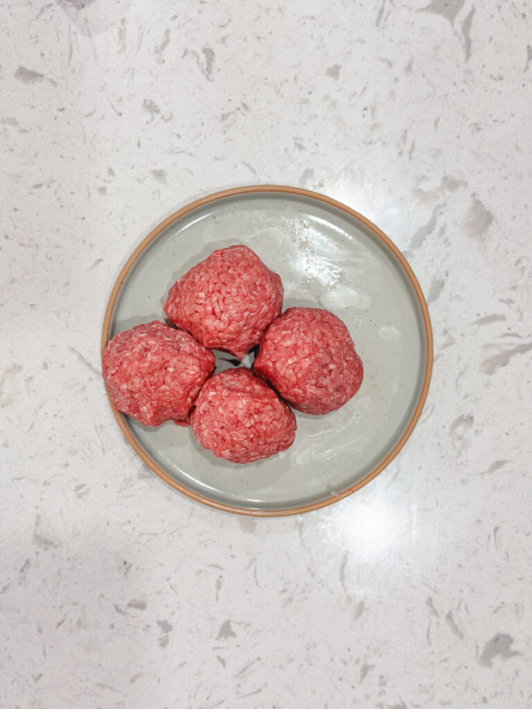 Balls of ground beef in a dish.