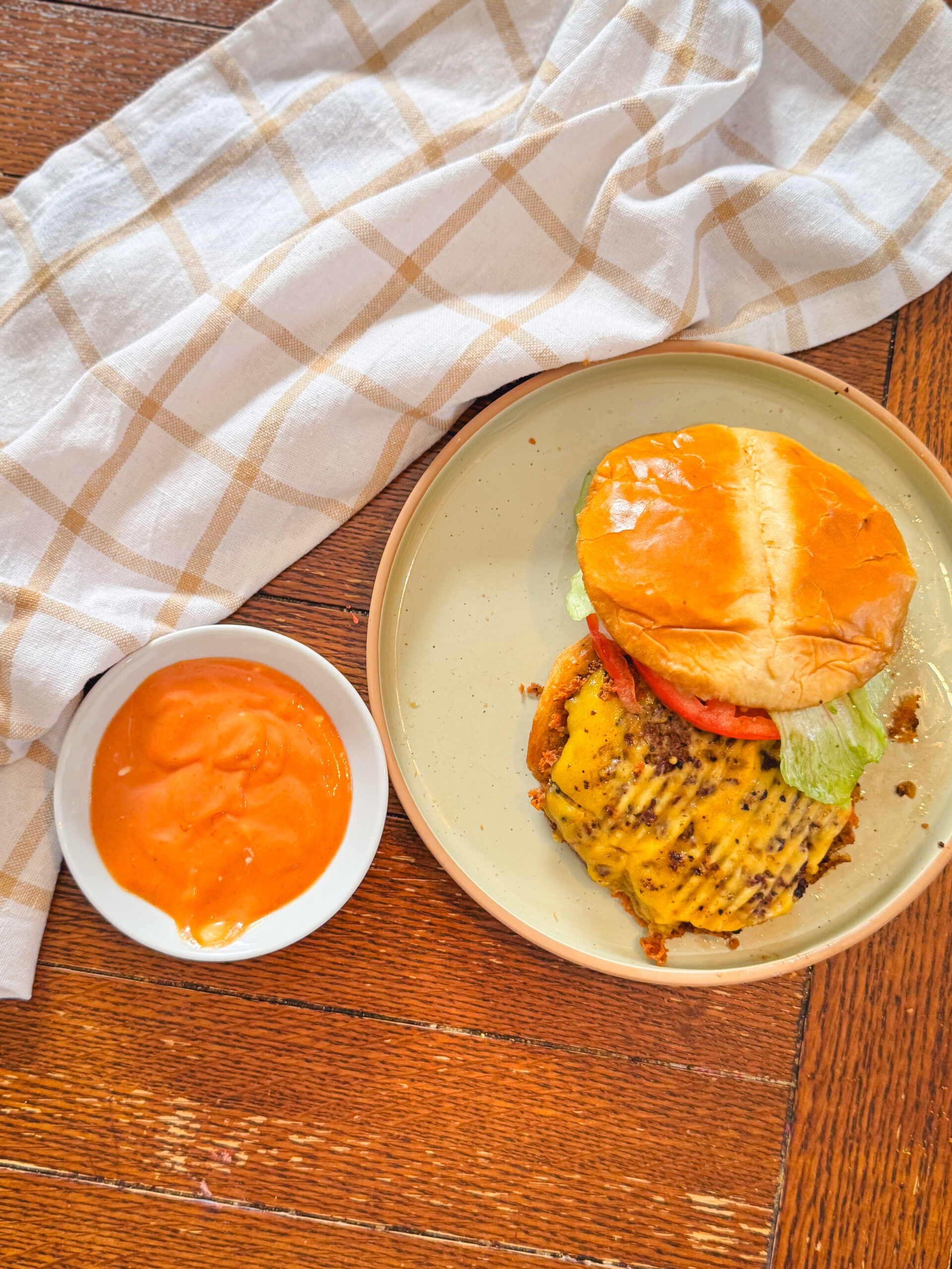Smash burger next to a delicious bowl of homemade burger sauce.