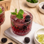 Blackberry mule garnished with fresh blackberries and mint on a serving plate.