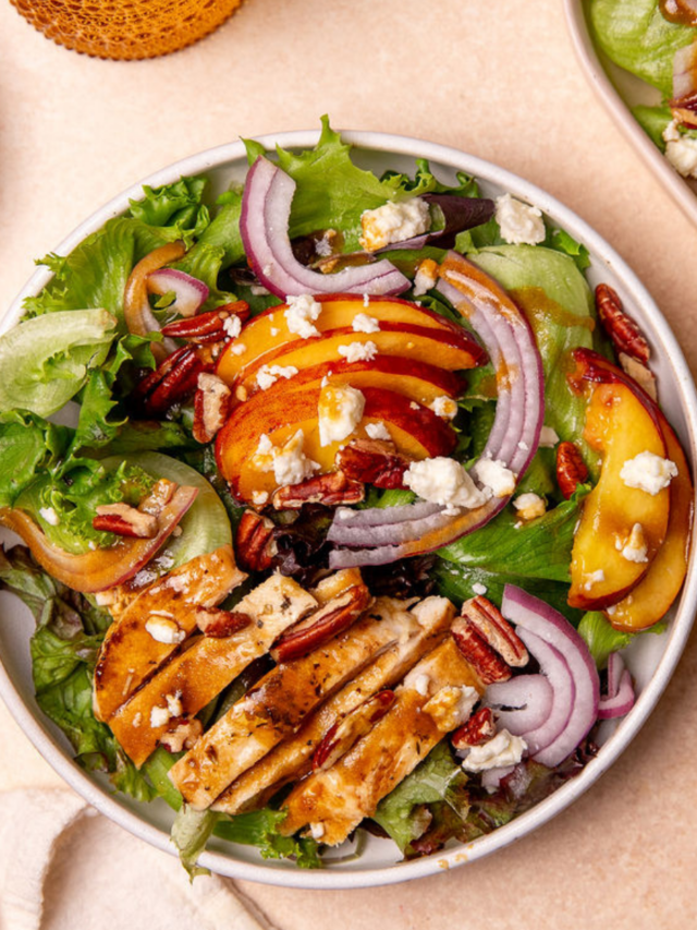 A serving of grilled chicken and peach salad in a white bowl.