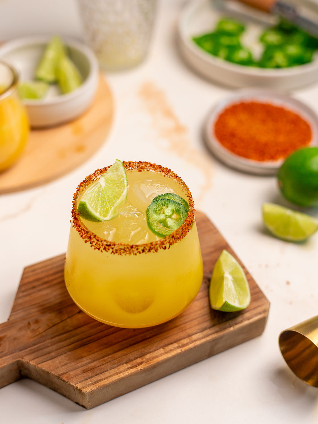 Spicy mockarita in a glass with Tajin on the rim on a wooden serving tray.