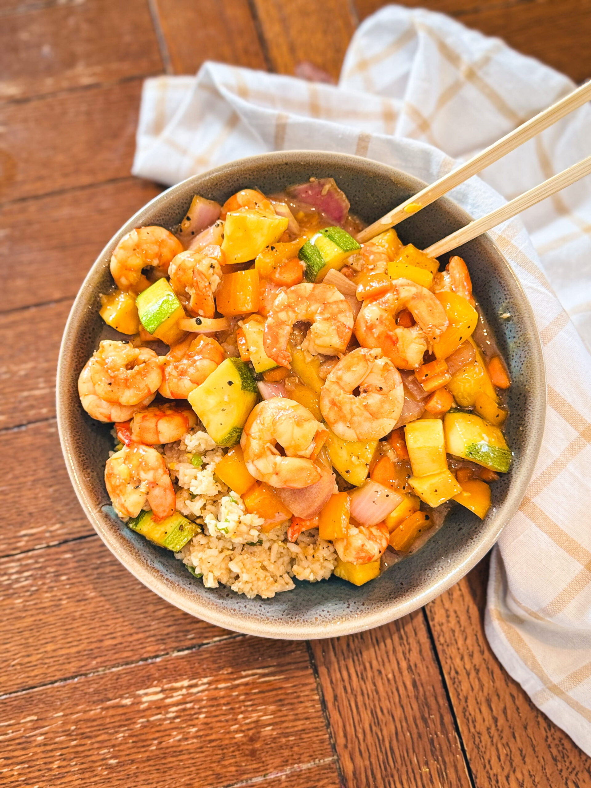 Sheet pan teriyaki shrimp in a bowl with chopsticks.