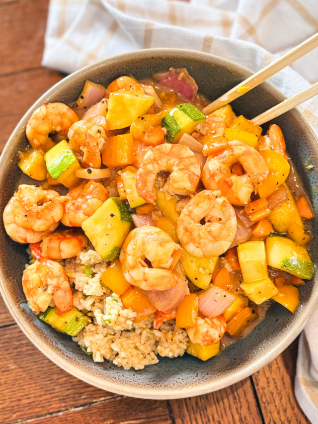 Sheet pan teriyaki shrimp in a bowl with chopsticks.