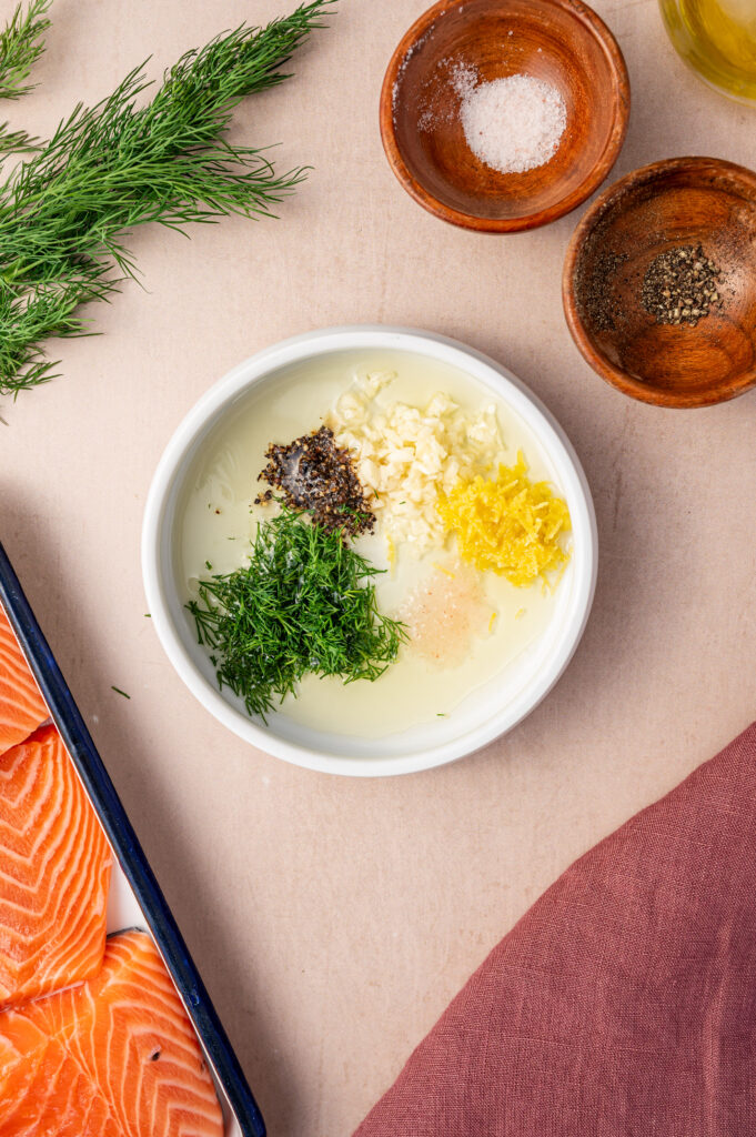 Ingredients for lemon dill sauce in a small white bowl.
