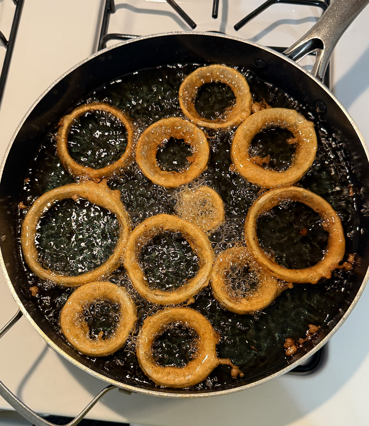 Frying beer battered onion rings.