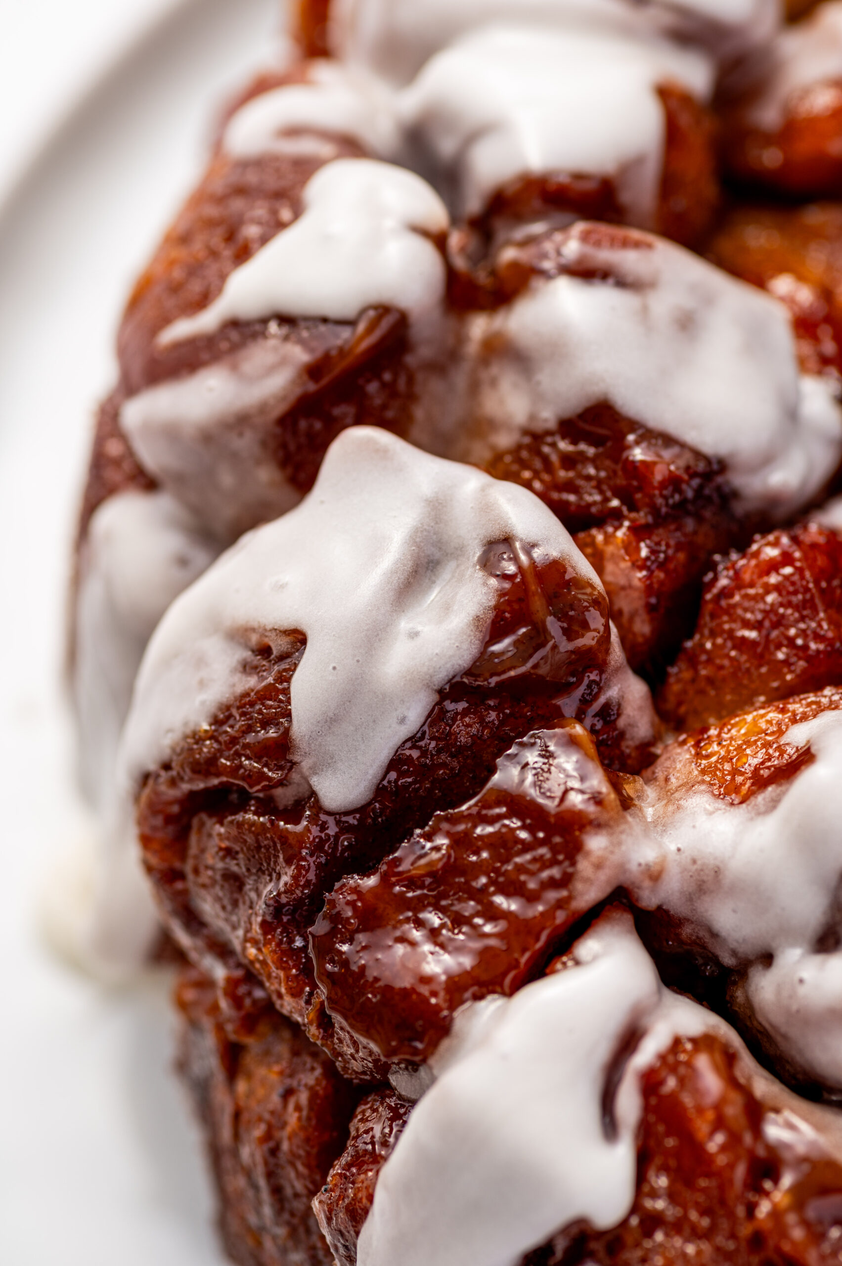 Close-up of gooey cinnamon roll monkey bread with icing.
