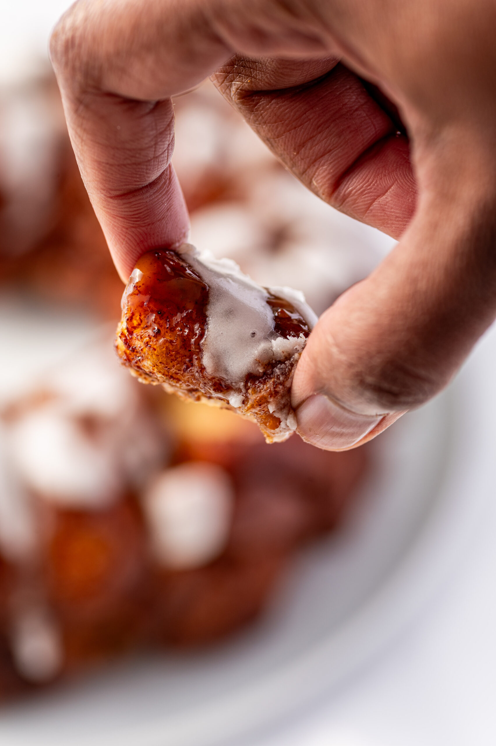 A piece of cinnamon roll monkey bread between two fingers.