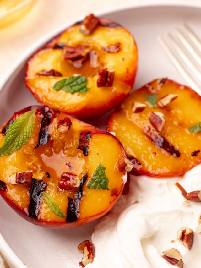 Close-up of grilled peaches garnished with mint and a side of Greek yogurt.