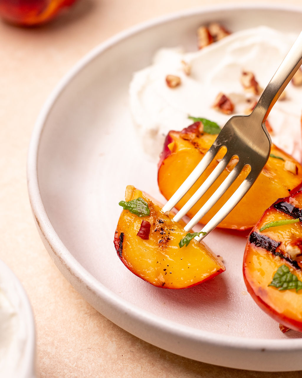Sticking a fork into a grilled peach.