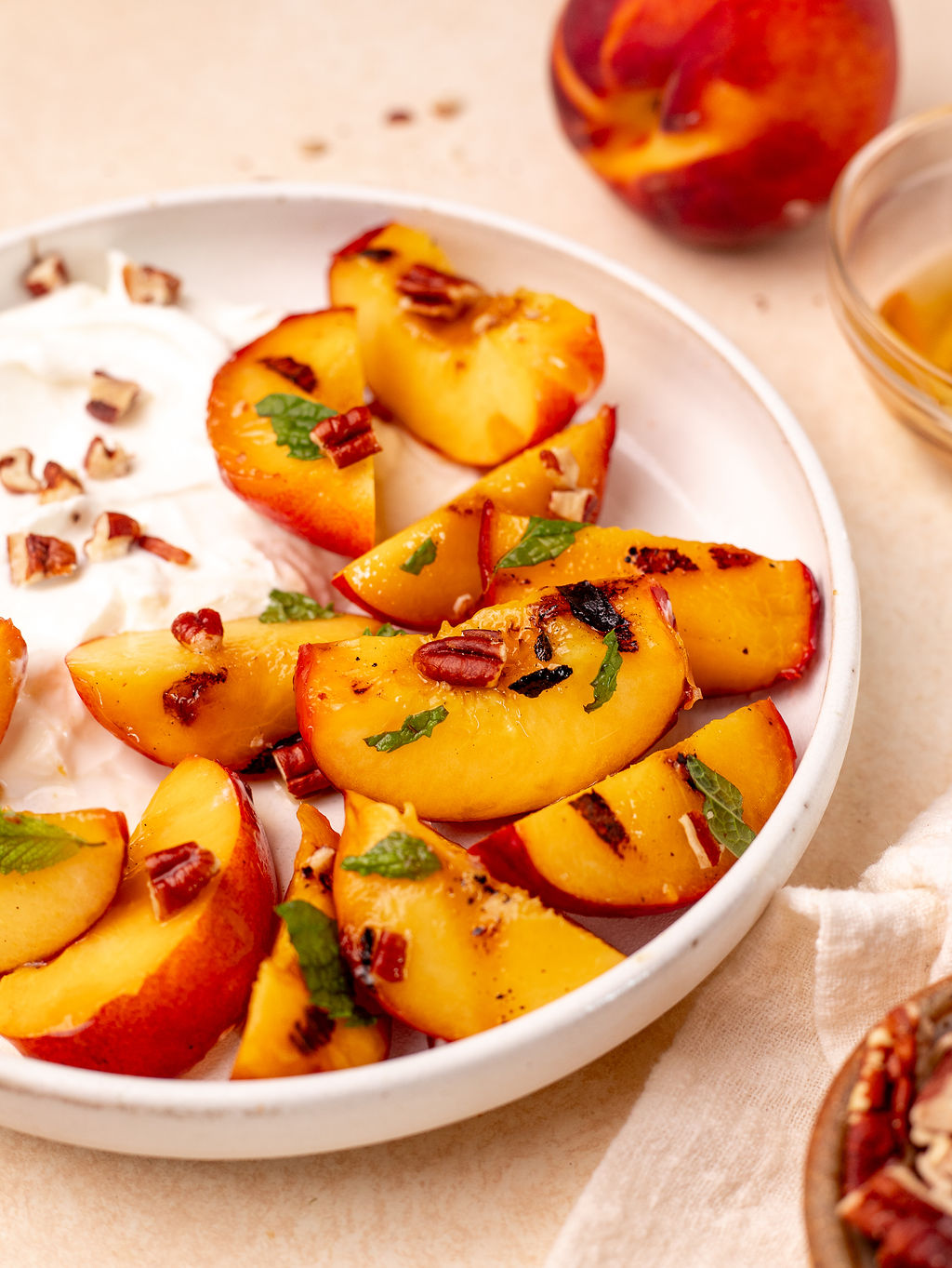 Grilled peaches quartered on a plate.