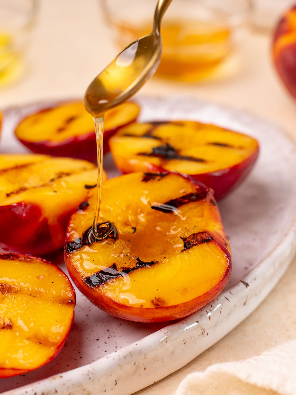 Drizzling honey on grilled peaches.