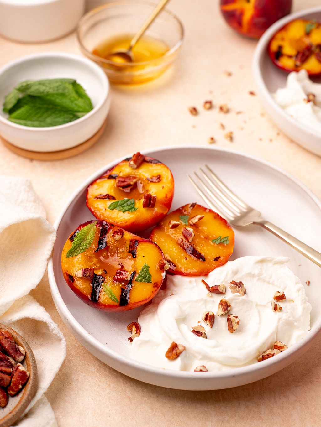 Grilled peaches on a plate with Greek yogurt on the side.