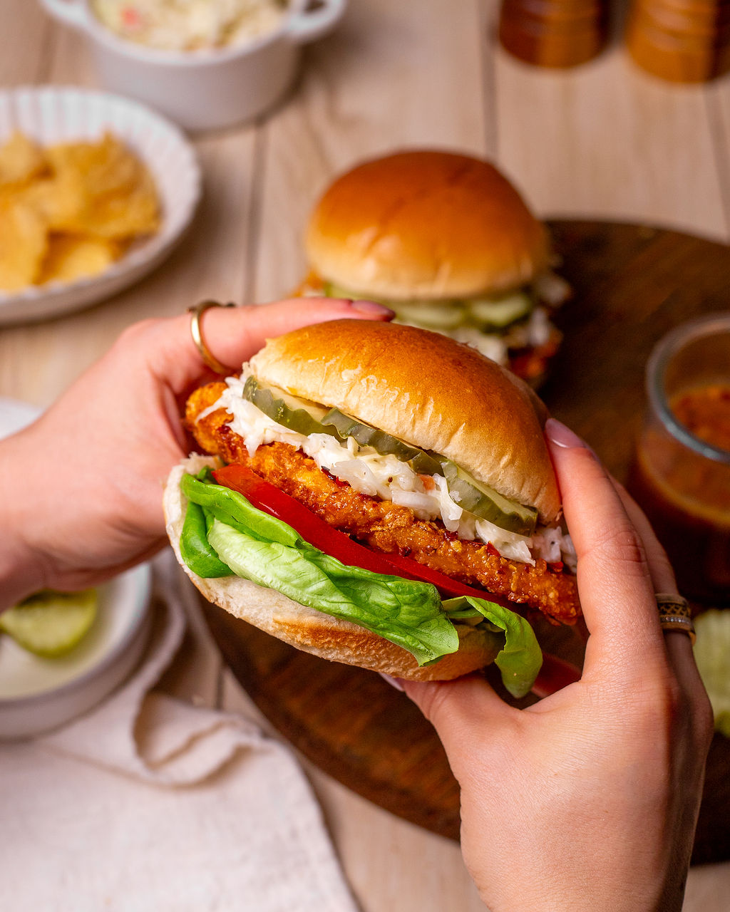Tasty hot honey chicken sandwich between two hands.
