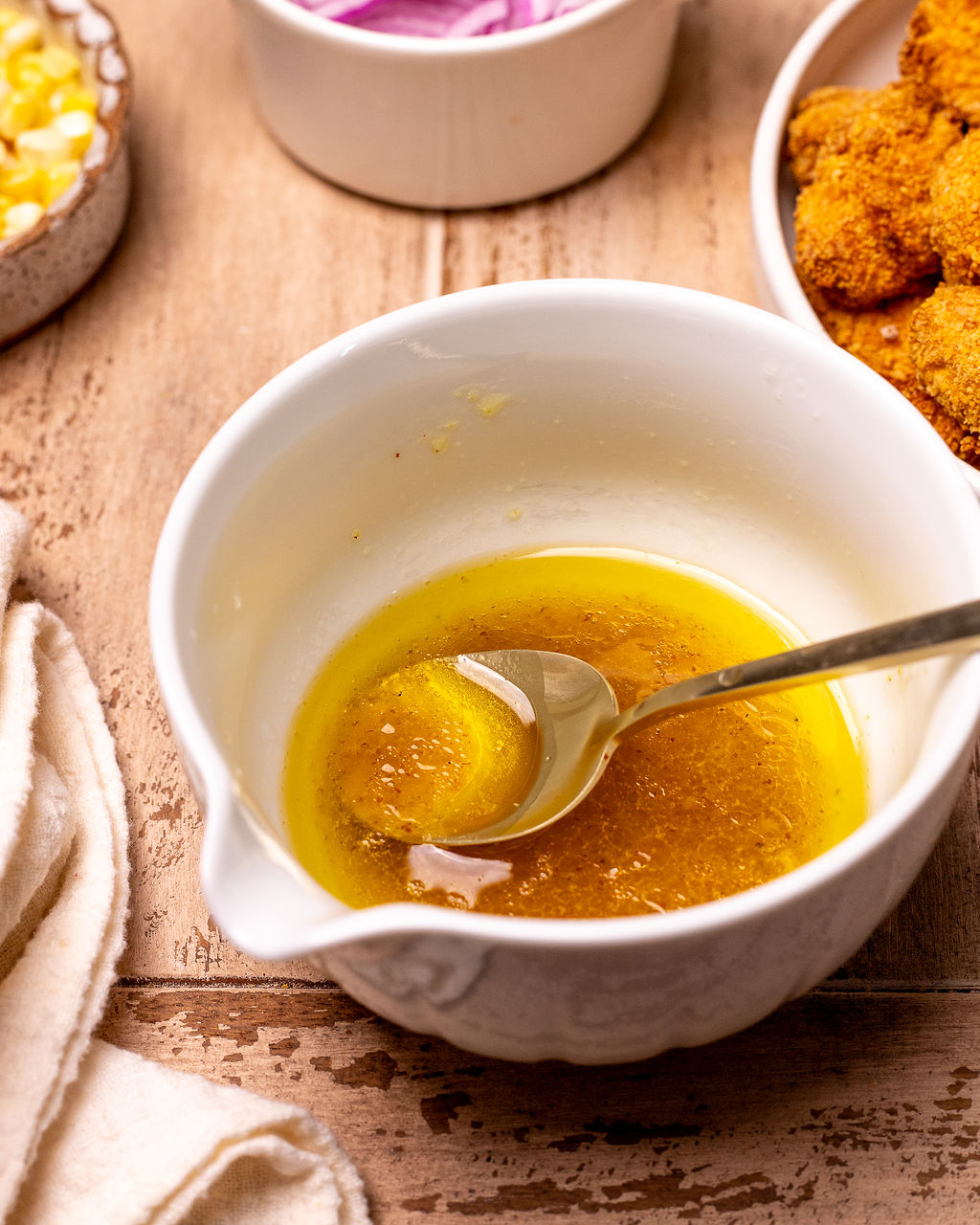 Mixing the dressing with a spoon.