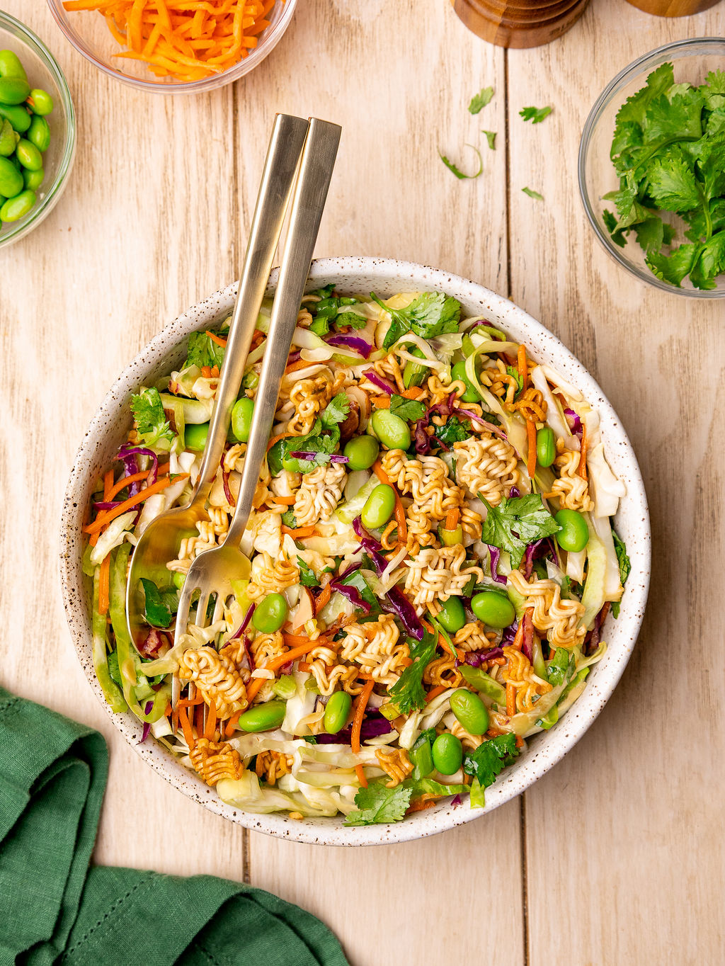Ramen noodle salad with salad tongs.